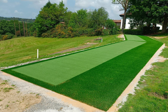 Tucson Outdoor tee line consisting of one continuous green synthetic grass strip surrounded by trees