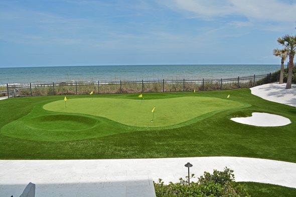 Tucson Synthetic grass golf green by the sea with yellow flags and a sand bunker