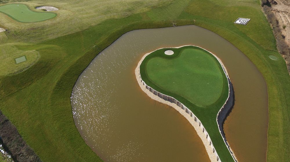 Tucson Aerial view of a vibrant green synthetic grass island in a natural pond on a golf course